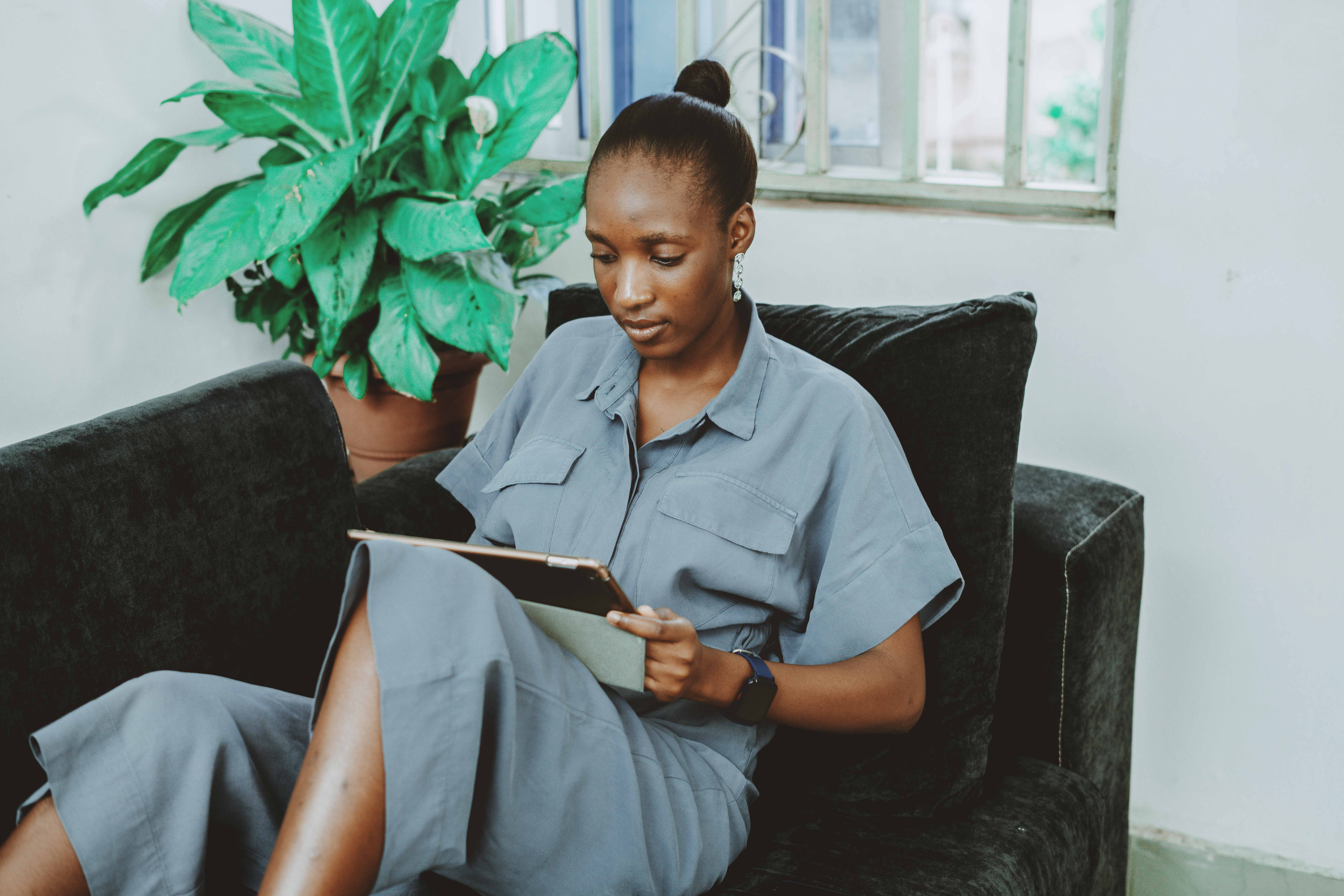Woman using a tablet in an Abuja home; Nigerian editorial photograph